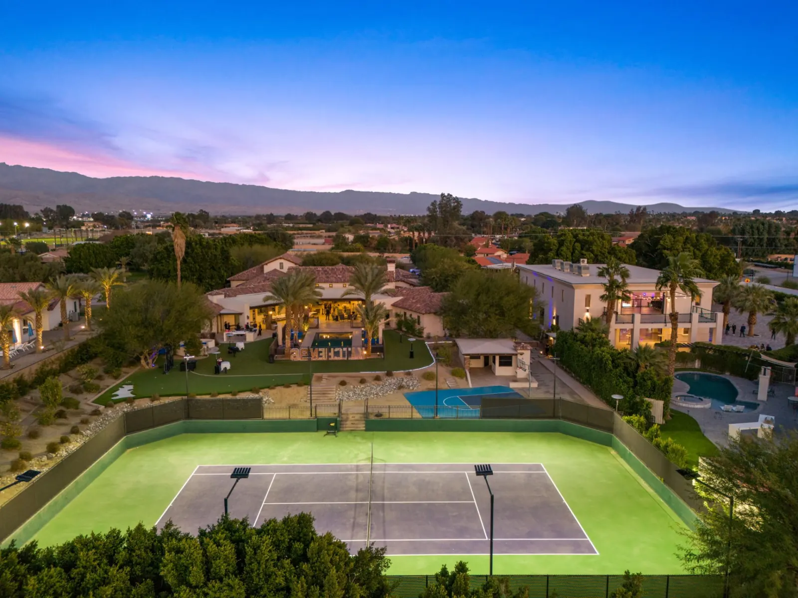 Rear lawn, pool and tennis court at sunset