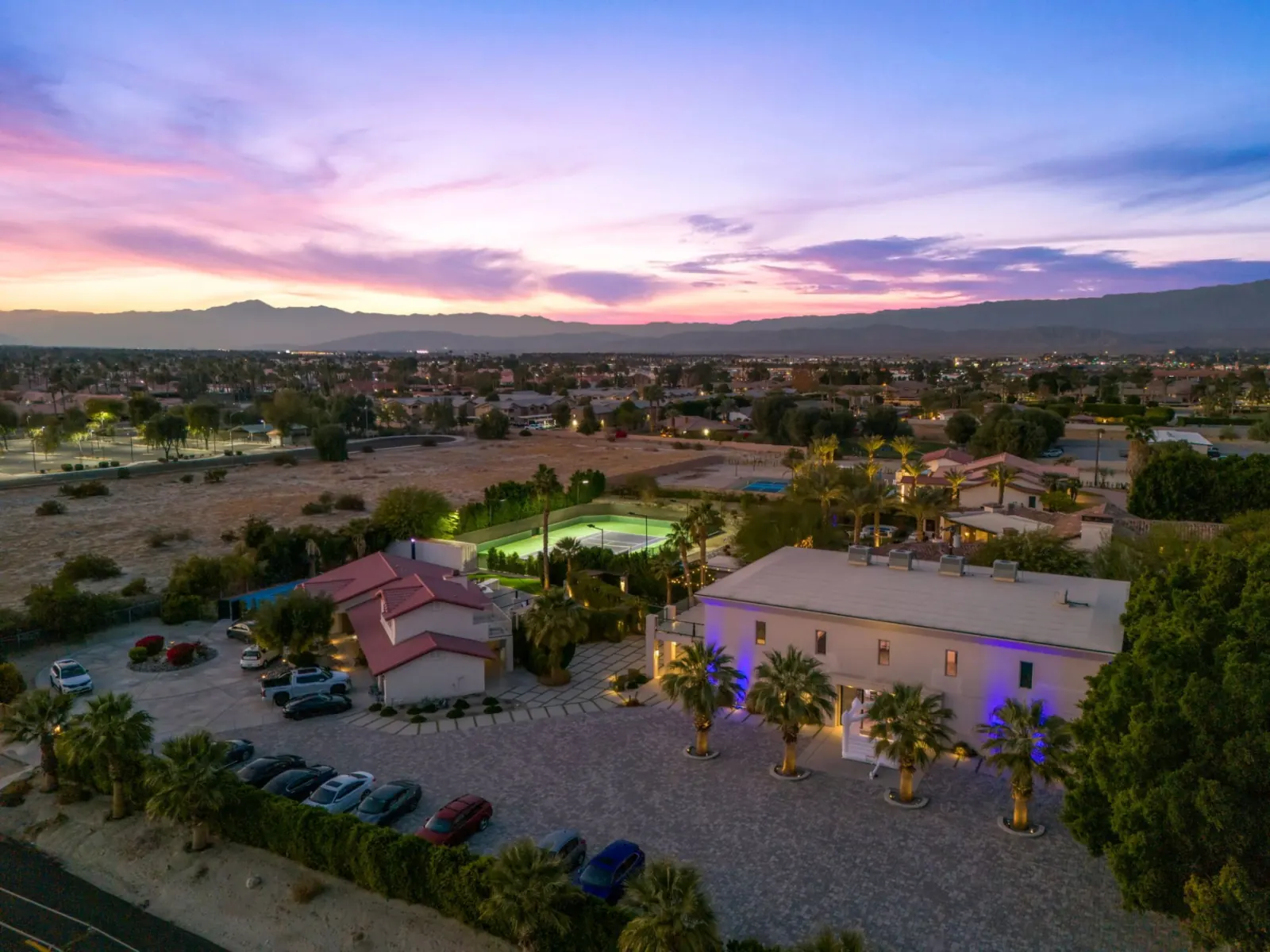 Estate at sunset with tennis court and palms