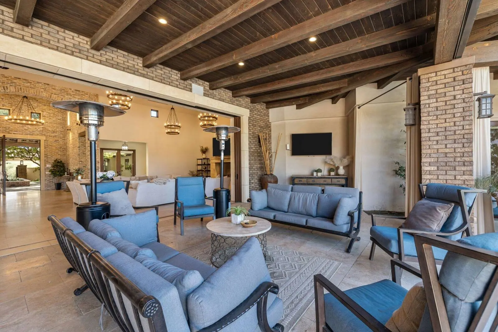 Covered patio lounge with brick columns and beamed ceiling